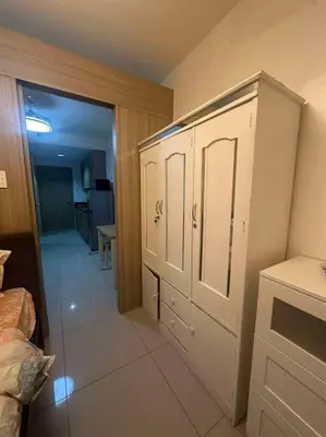 a bedroom with white cabinets and a hallway at Cozy shore 1 residences in Manila