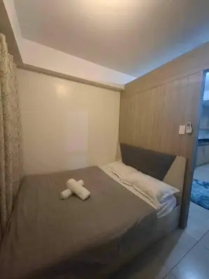 a bed with two white towels on top of it at Shore Staycation - Mall of Asia in Manila