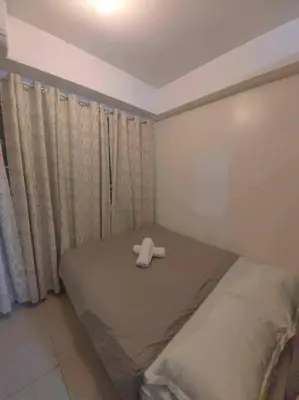 a room with a bed with a cross on it at Shore Staycation - Mall of Asia in Manila