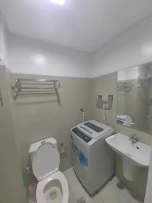 a bathroom with a toilet and a sink at Shore Staycation - Mall of Asia in Manila