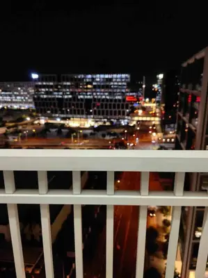 a view of a city at night from a balcony at Shore Staycation - Mall of Asia in Manila
