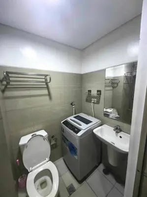 a bathroom with a toilet and a sink at Shore Staycation - Mall of Asia in Manila
