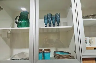 a cabinet with blue vases and bowls in it at 1BR self-contained CONDO in Makati with amenities! in Manila