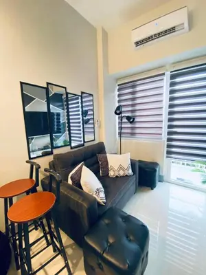 a living room with a couch and a table and stool at Jazz Cozy Abode in Manila