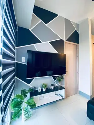 a living room with a large flat screen tv on a wall at Jazz Cozy Abode in Manila