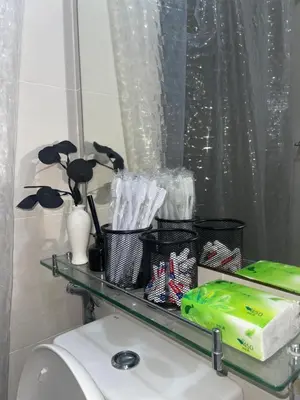 a glass shelf on top of a toilet in a bathroom at La Primera Deluxe in Manila