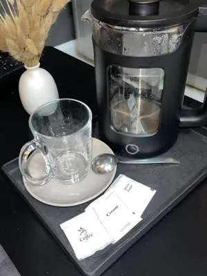 a tray with a coffee pot and a cup and spoon at La Primera Deluxe in Manila