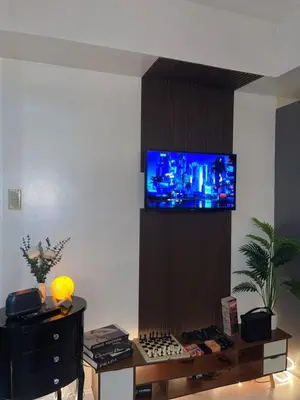 a living room with a tv on a wall at La Primera Deluxe in Manila
