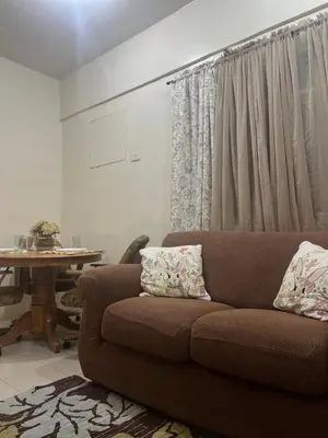 a living room with a brown couch and a table at 2301 Jazz View Condo in Manila