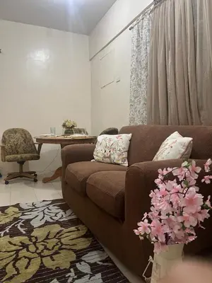 a living room with a brown couch and a table at 2301 Jazz View Condo in Manila