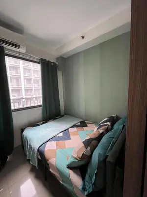a bedroom with a bed with a quilt on it at Casa Antonietta at Shores Residences in Manila