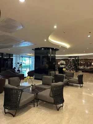 a lobby with chairs and a christmas tree in a building at Casa Antonietta at Shores Residences in Manila