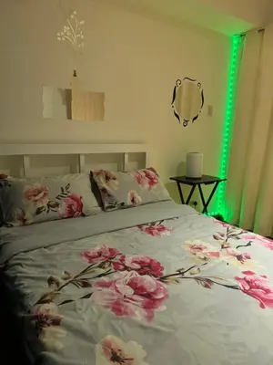 a bedroom with a bed with pink flowers on it at Azure Urban Dream Staycation in Manila