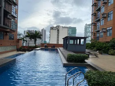 a swimming pool in the middle of a city with buildings at Porto Vita Towers in Manila