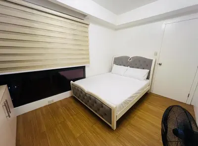 a small bedroom with a bed and a window at Porto Vita Towers in Manila