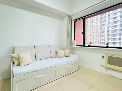 a white room with a bench in front of a window at Budget Accommodation at Ace Suites by the Famous Indoor Water Spa in Manila