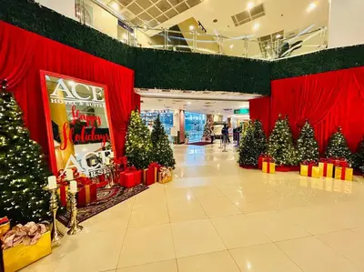 a group of christmas trees in a room with red curtains at Budget Accommodation at Ace Suites by the Famous Indoor Water Spa in Manila