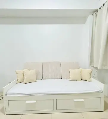 a white bed with pillows on it in a room at Budget Accommodation at Ace Suites by the Famous Indoor Water Spa in Manila