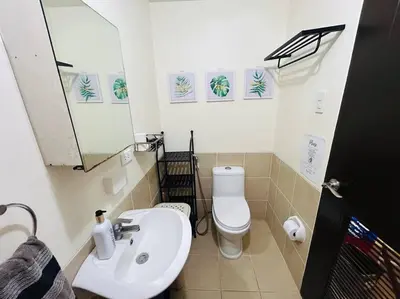 a bathroom with a white toilet and a sink at 1BR Calathea Place nr Airport, Netflix,50mbps Wifi in Manila