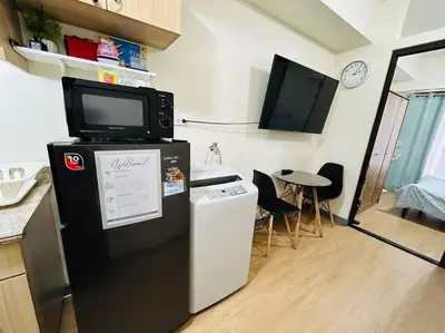a kitchen with a refrigerator with a tv on top of it at 1BR Calathea Place nr Airport, Netflix,50mbps Wifi in Manila