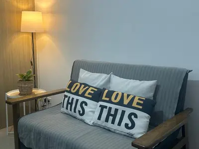 a blue chair with two pillows that say love love this at Shore 1 Residences Tower B in Manila