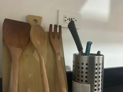 a bunch of wooden utensils in a cup next to knives at Shore 1 Residences Tower B in Manila
