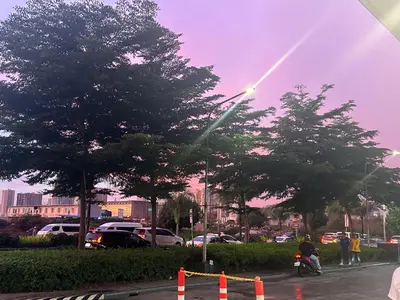 a rainbow in the sky over a parking lot with trees at Shore 1 Residences Tower B in Manila