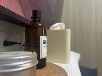 a bottle of oil sitting on a table next to a cup at Shore 1 Residences Tower B in Manila