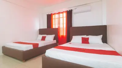 two beds in a room with red and white at RedDoorz at Najar Residences near NAIA Terminal in Manila