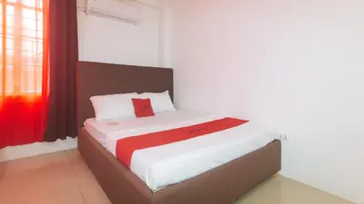 a bedroom with a bed with a red blanket at RedDoorz at Najar Residences near NAIA Terminal in Manila