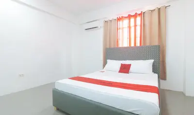 a bed in a room with a red pillow on it at RedDoorz at Najar Residences near NAIA Terminal in Manila