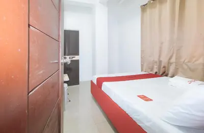 a small room with two beds and a closet at RedDoorz at Najar Residences near NAIA Terminal in Manila
