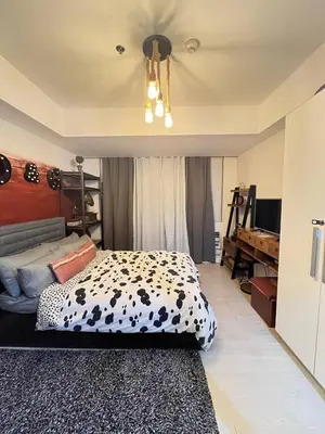 a bedroom with a cow patterned bed and a chandelier at Alphas Haven in Manila