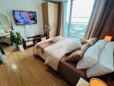 a bedroom with a large bed and a large window at Alphas Haven in Manila