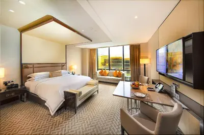 a hotel room with a bed and a flat screen tv at City Of Dreams - Nüwa Manila in Manila