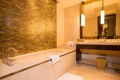 a bathroom with a tub and two sinks and a mirror at City Of Dreams - Nüwa Manila in Manila