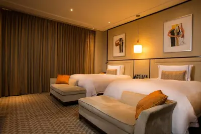 a hotel room with two beds and a couch at City Of Dreams - Nüwa Manila in Manila