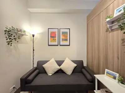 a living room with a couch with two pillows at 1BR Condotel with Balcony at FAME Residences #FM58 in Manila