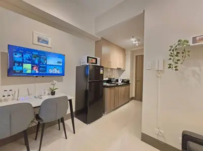 a kitchen with a dining table and a refrigerator at 1BR Condotel with Balcony at FAME Residences #FM58 in Manila