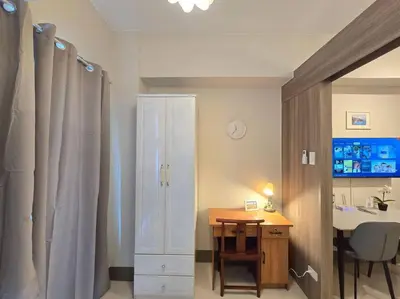 a bathroom with a sink and a desk with a table at 1BR Condotel with Balcony at FAME Residences #FM58 in Manila