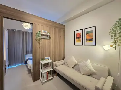 a living room with a couch and a bedroom at 1BR Condotel with Balcony at FAME Residences #FM59 in Manila