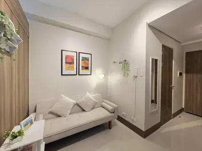 a living room with a white couch in a room at 1BR Condotel with Balcony at FAME Residences #FM59 in Manila