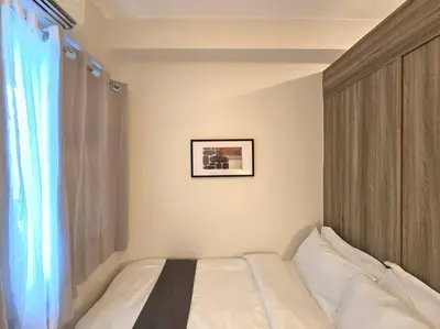 a bedroom with a bed with a picture on the wall at 1BR Condotel with Balcony at FAME Residences #FM60 in Manila