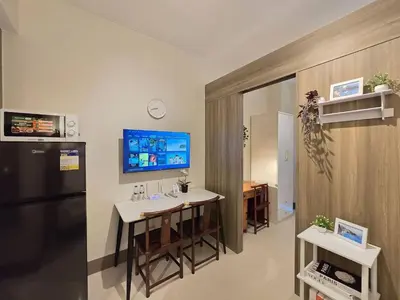 a kitchen with a small table and a refrigerator at 1BR Condotel with Balcony at FAME Residences #FM61 in Manila