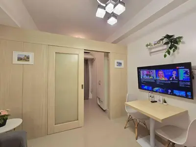 a living room with a table and a tv on the wall at 1BR Condotel with Balcony at SM Light Residences #LT08 in Manila