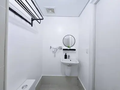 a white bathroom with a sink and a mirror at 1BR Condotel with Balcony at SM Light Residences #LT08 in Manila