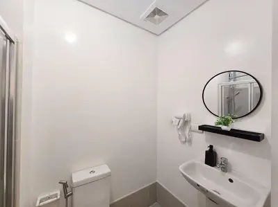 a white bathroom with a sink and a mirror at 1BR Condotel with Balcony at SM Light Residences #LT09 in Manila