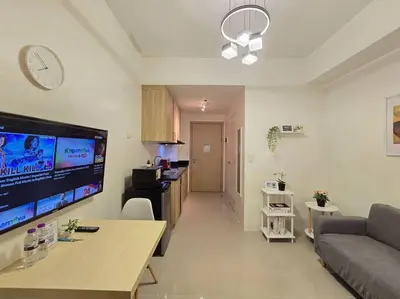 a living room with a couch and a large screen tv at 1BR Condotel with Balcony at SM Light Residences #LT09 in Manila