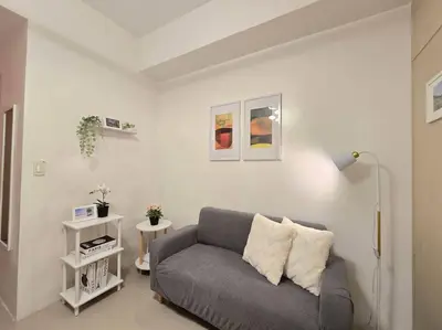 a living room with a gray couch in a room at 1BR Condotel with Balcony at SM Light Residences #LT09 in Manila