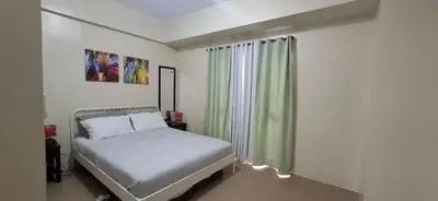 a small bedroom with a bed and a window at 1 Bedroom unit near NAIA T3 in Manila